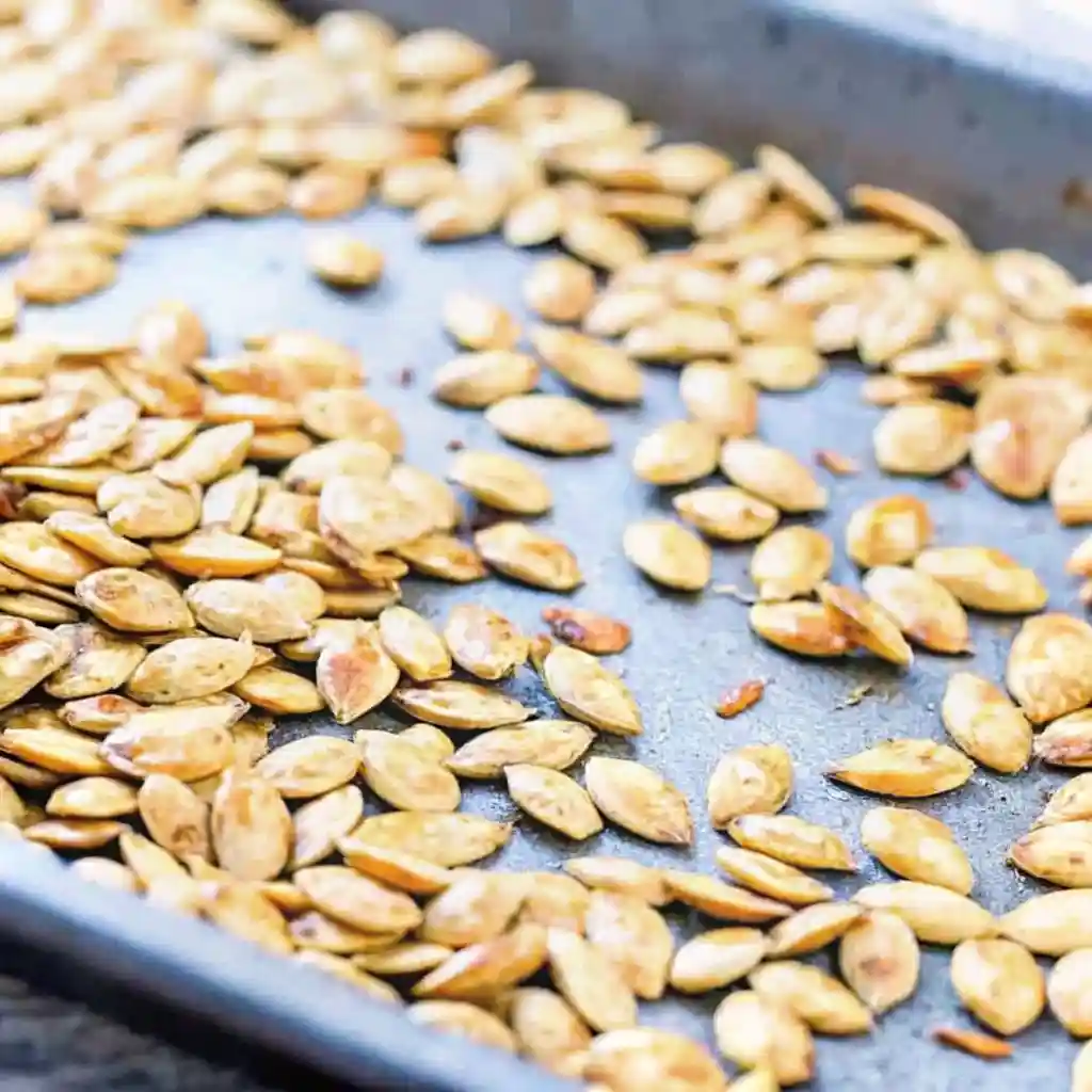 Pumpkin Seed Recipe That Delivers Bold Crunch Fast Pumpkin Seed Recipe Pumpkin seeds roasting on a baking sheet in a single layer