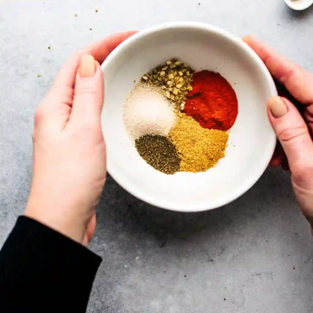 Air Fryer Chicken Breast : The Last Juicy Recipe You’ll Ever Need Air Fryer Chicken Breast Bowl of spices including oregano, garlic powder, paprika, salt, and pepper held by two hands