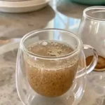 Bariatric Seed Drink Recipe: A Dietitian's Guide to the Viral Trend bariatric seed drink recipe A clear, double-walled glass mug filled with the finished bariatric seed drink, sitting on a marble countertop with a bowl of the dry seed mix in the background.