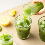 Paradise Matcha Lemonade Recipe: Copycat Starbucks matcha lemonade Pouring iced matcha lemonade into a glass with lemon slices nearby