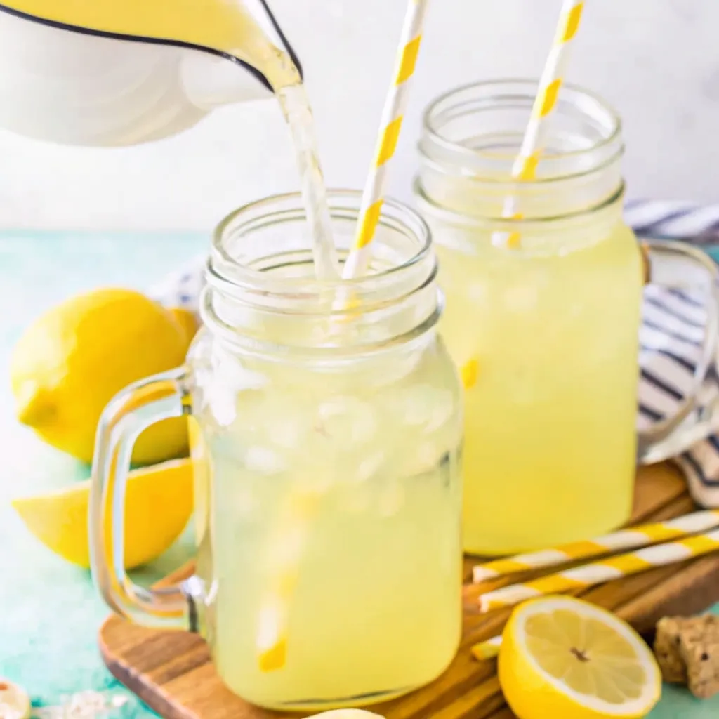Pickled Lemonade Recipe: The Definitive Guide pickled lemonade recipe Pickled lemonade being poured into mason jars with striped straws and lemon slices