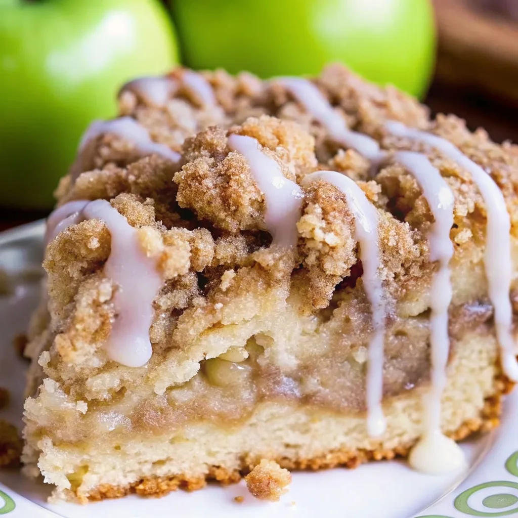 Apple Crumb Cake with Cinnamon Apple Drizzle – The Coziest Fall Dessert You’ll Ever Make Apple Crumb Cake with Cinnamon Apple Drizzle Close-up of a slice of apple crumb coffee cake with cinnamon streusel topping and white icing drizzle, with fresh green apples in the background.