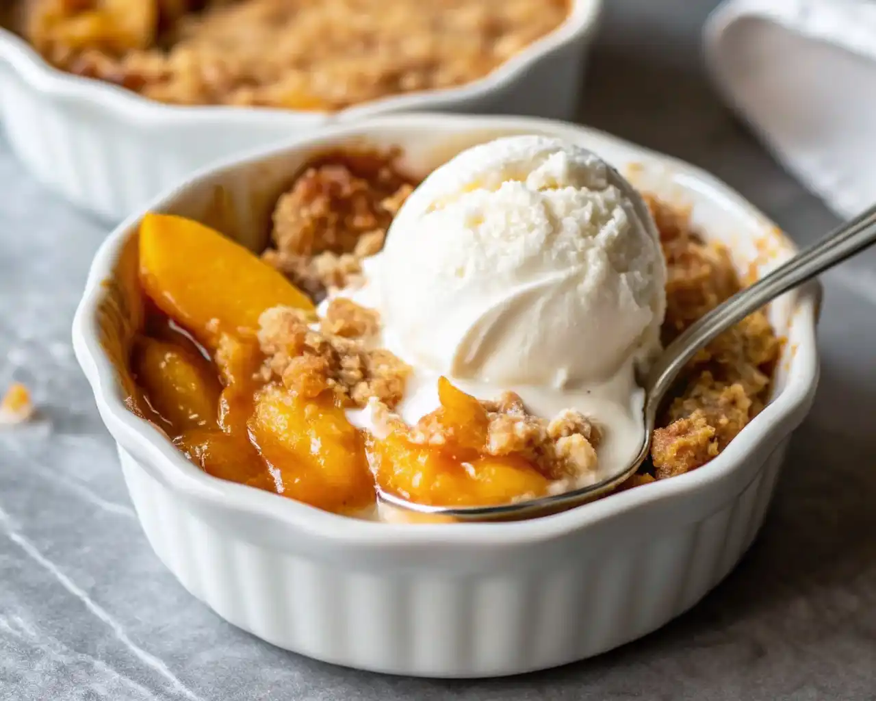 Easy Small Batch Peach Cobbler Recipe That Always Turns Out Perfect Easy Small Batch Peach Cobbler Recipe Small batch peach cobbler served in a white ramekin, topped with vanilla ice cream and a spoon.