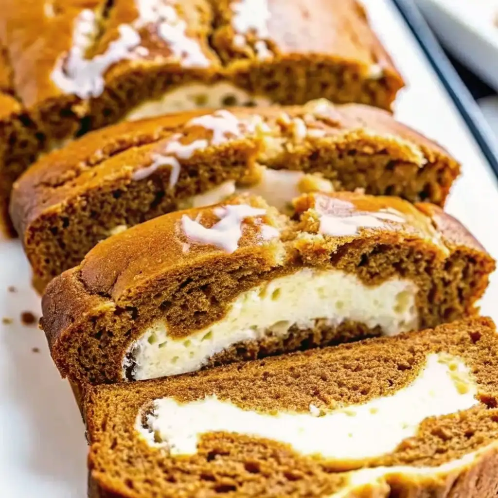 Pumpkin Cream Cheese Bread Pumpkin Cream Cheese Bread Close-up of sliced pumpkin cream cheese bread with a creamy swirl filling and light glaze on top