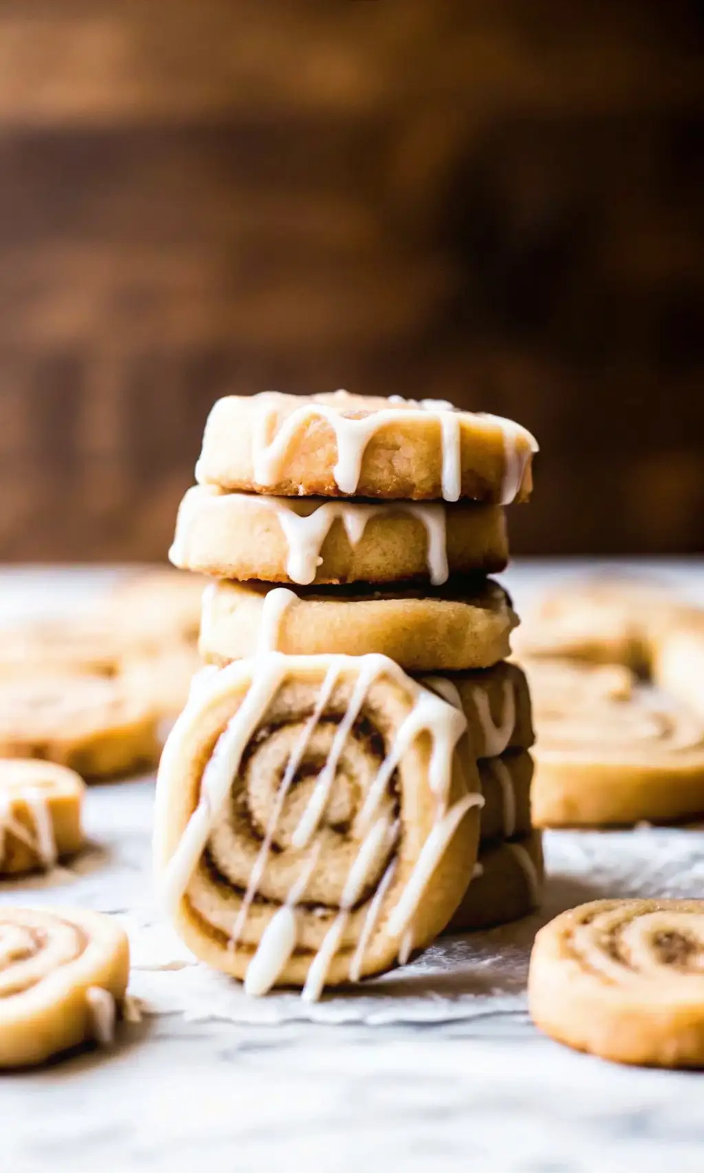 Cinnamon Roll Cookies Cinnamon Roll Cookies cinnamon roll cookies drizzled with white icing, with more cookies in the background.