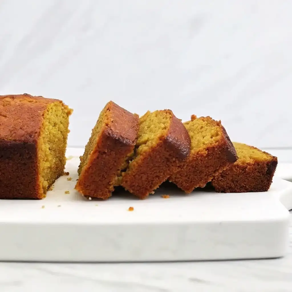Super Moist Pumpkin Bread with Cream Cheese Frosting Super Moist Pumpkin Bread Sliced super moist pumpkin bread on a white marble board, showing its golden soft texture and rich brown crust.