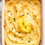 Baked mashed potatoes with golden top in white baking dish