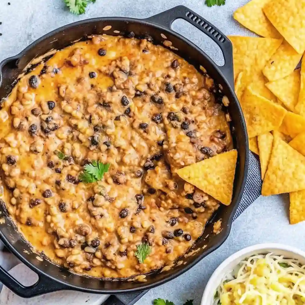 Loaded Cowboy Queso Dip | Best Cheesy Recipe Top 5 Cowboy Queso Recipe Overhead shot of Cowboy Queso dip with chips on the side, topped with cilantro.