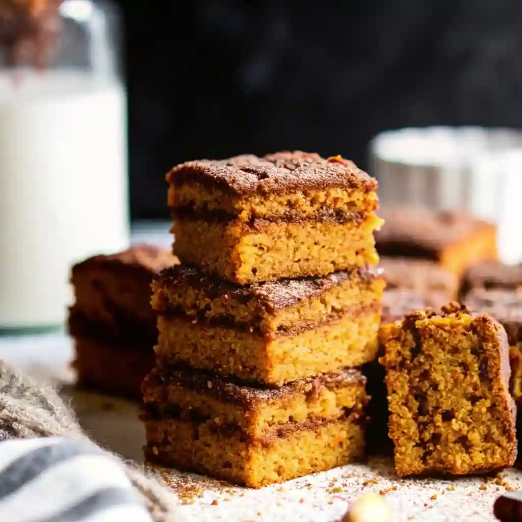 Pumpkin Snickerdoodle Snack Cake Easy Fall Dessert Pumpkin Snickerdoodle Snack Cake Pumpkin Snickerdoodle Snack Cake with cinnamon sugar topping on a white plate