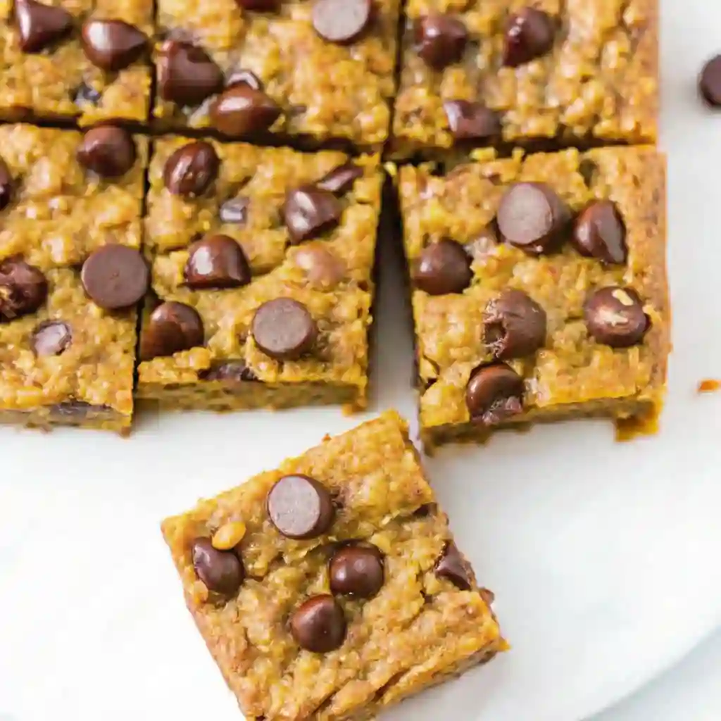 Pumpkin Oatmeal Bars Healthy Baking Secrets for Fall pumpkin oatmeal bars Homemade pumpkin oatmeal bars with chocolate chips on top, sliced into squares.