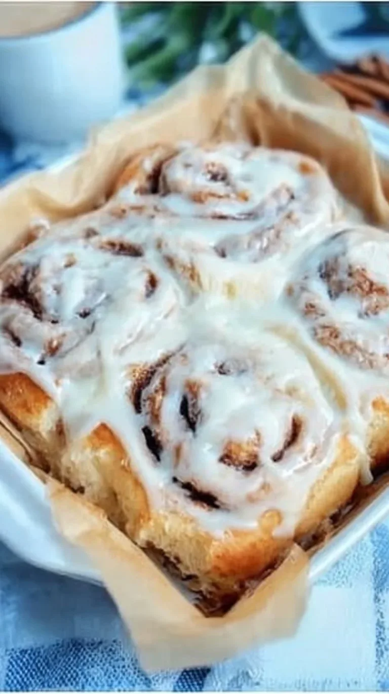 Best Soft Cinnamon Roll Recipe fruit smoothie bowl Freshly baked soft cinnamon rolls topped with icing on a wooden table