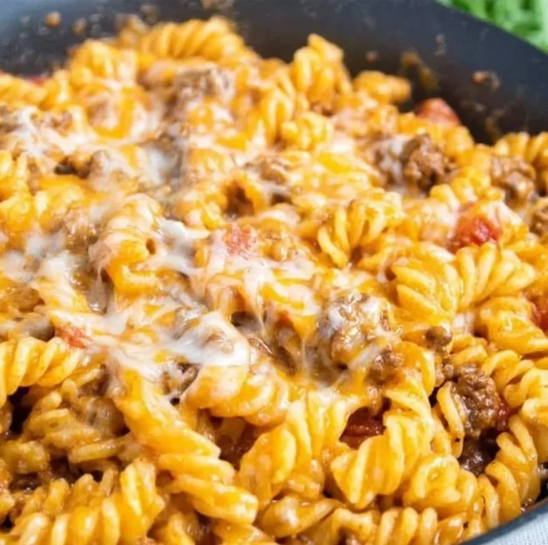 Delicious cheesy taco pasta topped with cheese and herbs in a bowl