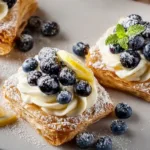 Blueberry lemon cream pastries topped with fresh blueberries and lemon zest
