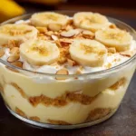 Bowl of homemade banana pudding layered with bananas and whipped cream